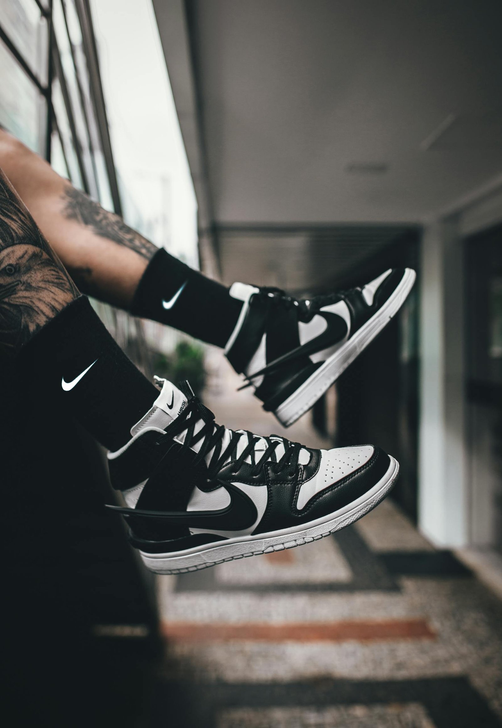 Fashionable black and white high-top sneakers with Nike logo in a modern urban setting.